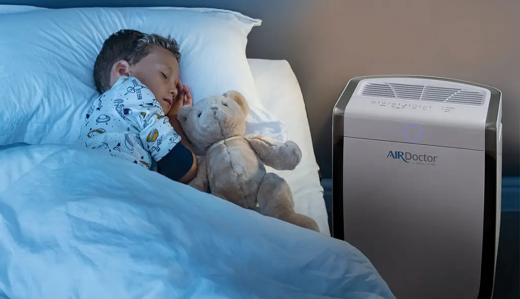 young biy sleeping peavefully besides Airdoctor 3000